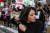 27일(현지시간) 미국 뉴욕에서 열린 시위에 참가한 한 여성이 머리카락을 자르고 있다. 로이터=연합뉴스