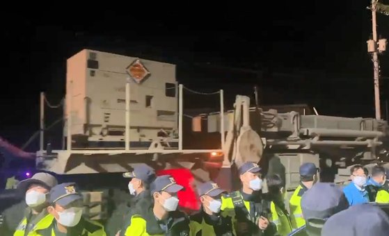 6일 밤 경북 성주의 주한미군 고고도미사일방어(THAADㆍ사드) 체계 기지에 성능 개량 장비를 실은 트럭이 경찰의 호위 아래 들어가고 있다. 뉴스1