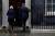 리즈 트러스 영국 총리(왼쪽)가 20일(현지시간) 오후 긴급 기자회견에서 “찰스 3세 국왕에게 사임한다고 밝혔다”고 말한 뒤 런던 다우닝가 10번지 총리관저로 돌아가고 있다. [로이터=연합뉴스]