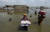 최악의 홍수 피해를 입은 파키스탄에서 이재민들이 물에 잠긴 집에서 짐을 옮기고 있다. AP=연합뉴스