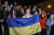 우크라이나 수도 키이우 마이단 광장에 모인 시민들이 11일(현지시간) 귝기를 든 채 헤르손 탈환을 축하하고 있다. AFP=연합뉴스