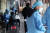 지난 23일 오전 서울 송파구 보건소에 마련된 선별검사소에서 시민들이 진단 검사를 받기 앞서 의료진과 문답을 나누고 있다.  뉴스1