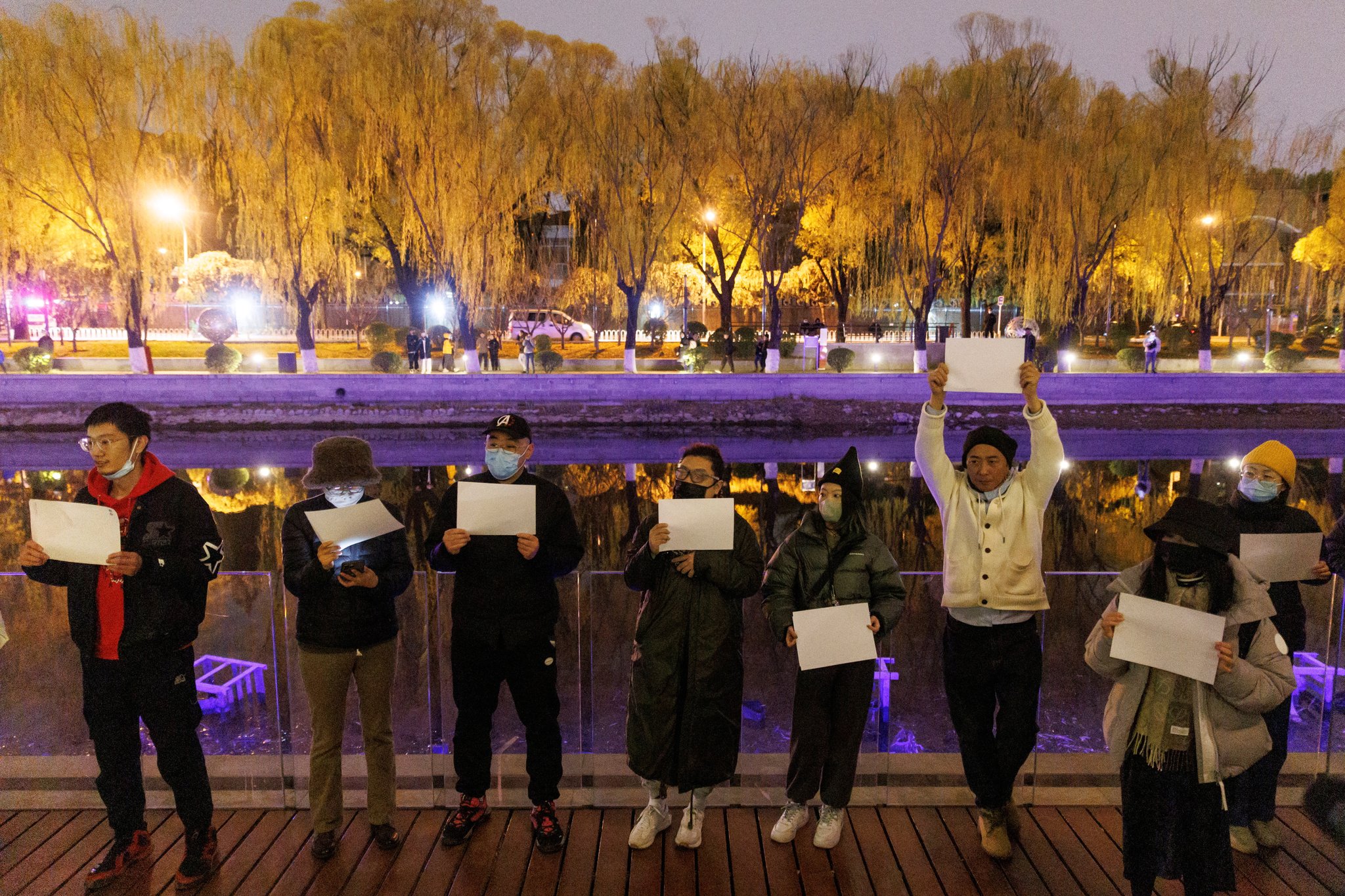 27일 베이징 대사관 단지 인근 량마허 강변에서 시민들이 백지를 들고 11·24 우루무치 화재 참사에서 숨진 희생자를 추모하고 있다. 이날 시위는 1989년 천안문 사태 이후 베이징 가두에서 벌어진 첫번째 대규모 시위다. 로이터=연합뉴스