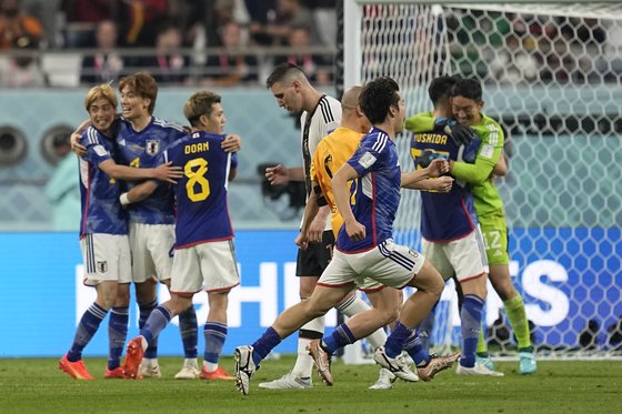 23일(현지시간) 카타르 월드컵 조별리그 E조 독일 vs 일본전에서 역전패한 독일의 그라브리가 기뻐하는 일본 선수들 사이를 고개 숙인 채 지나고 있다. AP=연합뉴스