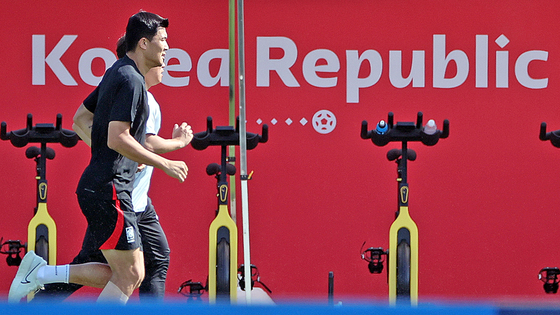 축구대표팀 김민재(왼쪽)가 4일 카타르 도하 알에글라 훈련장에서 팀훈련에 빠진 채 혼자 러닝을 하고 있다. 연합뉴스