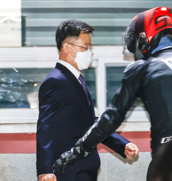 지난해 10월 15일 김만배씨(왼쪽)가 서울구치소를 나서고 있다. 김씨를 마중 나온 남성이 ‘헬멧남’으로 불린 최우향씨다. [연합뉴스]
