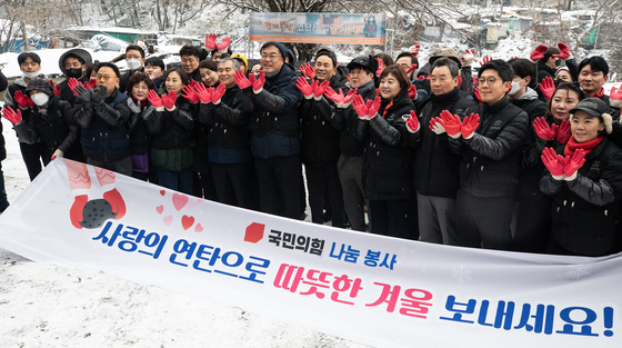 국민의힘 정진석 비상대책위원장을 비롯한 지도부와 자원봉사자들이 21일 서울 강남구 구룡마을에서 연탄 나눔 봉사 활동에 앞서 기념 촬영을 하고 있다. 뉴스1