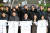 김진열 군위군수(앞줄 가운데)가 지난 13일 오전 경북 군위군 군위전통시장에서 열린 '대구편입법 국회통과 기념 군민 한마당' 행사에 참석해 군의원을 비롯한 내빈과 함께 축하 티셔츠를 들어 보이며 기념 촬영을 하고 있다. 뉴스1