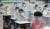 칸막이가 설치된 책상에서 마스크를 쓰고 수업을 듣는 초등학교 1학년 학생들의 모습. [뉴스1]