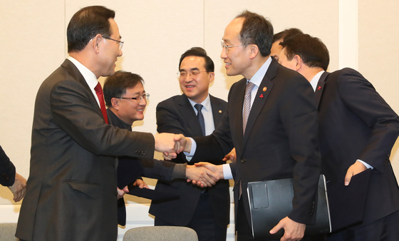 주호영 국민의힘 원내대표(왼쪽)와 악수하는 추경호 경제부총리(오른쪽), 박홍근 더불어민주당 원내대표(뒷줄 가운데) 등이 지난달 22일 서울 여의도 국회에서 2023년 예산안 합의를 마친 뒤 인사하고 있다. 뉴스1