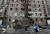 마리우폴 어린이가 24일 부서진 자동차와 파괴된 아파트 건물 앞에 서 있다. 로이터=연합뉴스