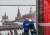모스크바 시내에 걸린 옛 전승절 퍼레이드 사진 앞의 모스크바 시민. EPA=연합뉴스