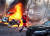  러시아의 도심 공격이 벌어진 10일(현지시간) 한 우크라이나 의료진이 거리에서 불타고 있는 차량 사이를 지나고 있다. 로이터=연합뉴스