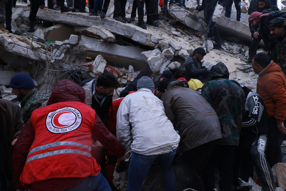 지난 6일 튀르키예 동남부에서 발생한 대형 지진으로 피해를 입은 시리아에서 시리아적신월사 직원과 봉사원들이 구호활동을 펼치고 있다. [시리아적신월사] 