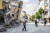  11일(현지시간) 튀르키예 하타이주에서 지진으로 파손된 건물 앞을 사람들이 지나고 있다. AFP=연합뉴스