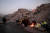 12일(현지시간) 튀르키예와 시리아 국경 지역에서 규모 7.8의 강진이 발생한 이후 실종자 가족들이 무너진 건물 잔해 앞에서 불을 피워놓고 있다. AFP=연합뉴스