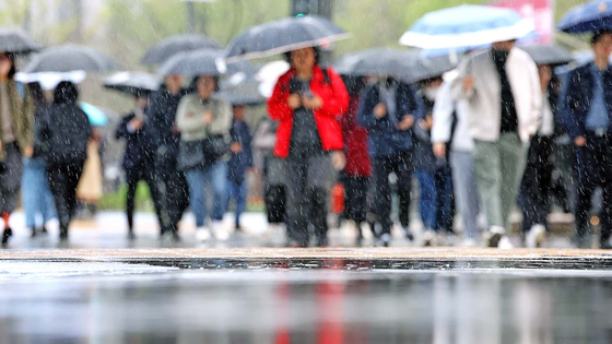  봄비가 내린 5일 오전 서울 종로구 광화문네거리에서 우산을 쓴 시민들이 발걸음을 재촉하고 있다. 연합뉴스