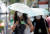 지난달 28일(현지시간) 태국 방콕의 직장인들이 우산을 사용하여 햇빛을 차단하고 선풍기로 더위를 식히고 있다. EPA=연합뉴스
