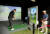 이대호(왼쪽)가 17일 제주 핀크스 골프장에서 열린 SK텔레콤 채리티 오픈을 앞두고 스크린골프 부스에서 연습을 하자 최경주가 이를 바라보고 있다. 사진 KPGA