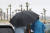 지난 18일 오후 제주시 함덕해수욕장에서 관광객들이 비와 강풍을 피해 발걸음을 옮기고 있다. 사진 뉴스1