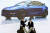 2020년 7월 중국 상하이에서 일론 머스크 테슬라 CEO(왼쪽)이 모델Y 사진 앞에서 현지 관계자와 악수를 나누고 있다. 로이터=연합뉴스