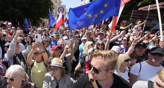 지난 4일(현지시간) 폴란드의 수도 바르샤바에서 열린 반정부 시위. 시민들은 폴란드 국기와 유럽연합기를 들고 시위를 벌였다. AP=연합뉴스 