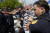 도널드 트럼프 전 미국 대통령이 13일(현지시간) 플로리다주 마이애미 연방법원을 떠날 때 죄수복 모양의 옷을 입은 한 남성이 트럼프가 탄 차량 앞으로 뛰어들었다가 경찰에 제지당하고 있다. AP=연합뉴스