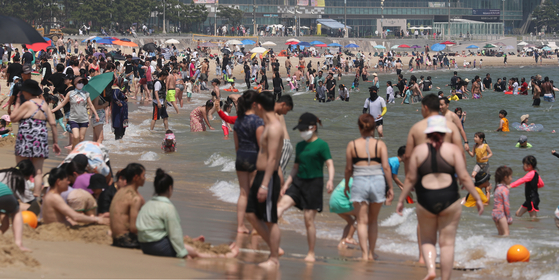  무더위가 기승을 부린 18일 오후 부산 해운대해수욕장을 찾은 피서객들이 물놀이를 즐기며 더위를 식히고 있다. 사진 뉴스1