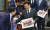 이재명 더불어민주당 대표가 21일 국회정책의원총회에서 후쿠시마 오염수 방류를 규탄하는 피켓을 들고 의원들과 인사하고 있다. 김현동 기자