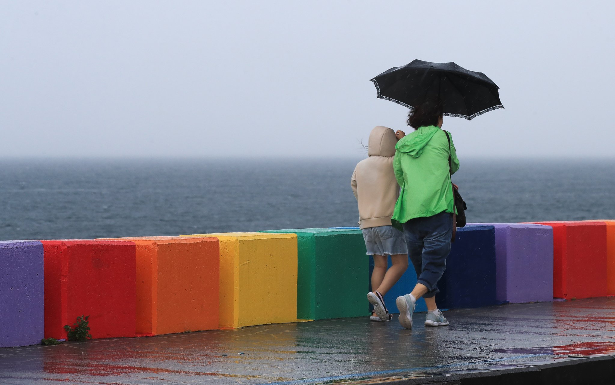 25일 제주시 무지개해안도로에서 우산을 쓴 시민이 걸어가고 있다. 뉴시스