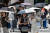 17일 일본 도쿄 시내에서 시민들이 햇빛을 피하기 위해 양산을 쓰고 횡단보도를 건너고 있다. AFP=연합뉴스 