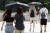 지난 19일 오후 서울 용산구 국립중앙박물관을 찾은 시민들이 양산을 펼쳐 따가운 햇빛을 피하고 있다. 뉴스1
