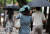 소나기가 내린 26일 서울 중구 정동길에서 우산을 챙기지 못한 시민들이 손수건으로 비를 막은 채 발걸음을 옮기고 있다. 뉴스1