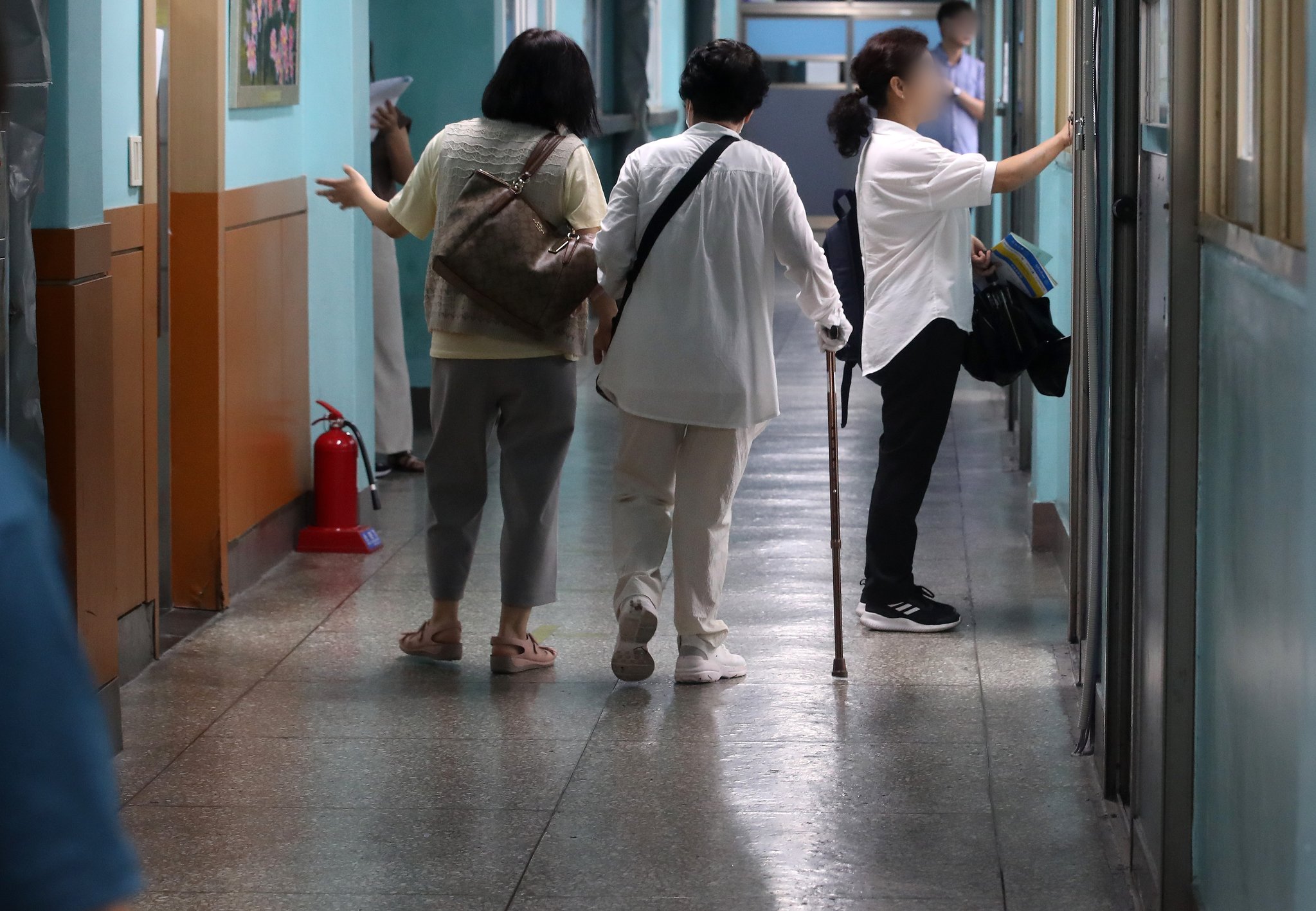 서울 용산구 선린중학교 고사장에서 지팡이를 짚은 한 고령의 응시생이 입실하고 있다.뉴스1