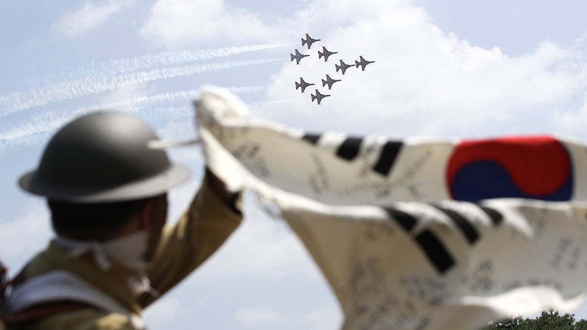 광복군 분장을 한 관람객이 충남 천안 독립기념관에서 축하비행을 펼치는 공군 특수비행팀 '블랙이글스'를 향해 태극기를 흔들고 있다. 뉴스1
