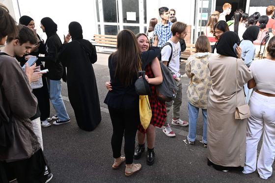 프랑스 고등학생들이 지난 7월 북동부 스트라스부르의 한 고등학교에서 시험 결과를 확인하고 있다. 일부 여학생은 발까지 내려오는 아바야를 입고 있다. AFP=연합뉴스
