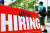 한 남성이 미국 버지니아주 알링턴의 식당 밖에 붙어있는 '지금 채용중' 표지판 앞을 지나가고 있다. AFP=연합뉴스
