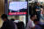 북한이 탄도미사일로 추정되는 우주발사체를 발사한 지난 24일 오전 시민들이 서울역 대합실에서 방송으로 관련 뉴스를 지켜보고 있다.   연합뉴스