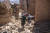9일(현지시간) 물라이 브라힘 마을의 주민들이 잔해 위로 조심스럽게 움직이고 있다. AP=연합뉴스