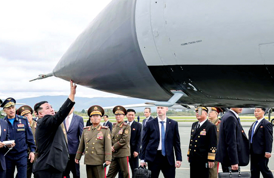 북한 김정은 국무위원장이 지난 16일 블라디보스토크 크네비치 군비행장에서 극초음속미사일 킨잘이 장착된 미그-31 전투기를 만져보고 있다. 로이터=연합뉴스