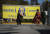 캐나다 브리티시컬럼비아주 서리에서 시크교도 여성들이 18일(현지시간) 시크교 분리주의 운동 지도자로 지난 6월 총에 맞아 숨진 하르딥 싱 니자르의 사진이 있는 칼리스탄 건국 플래카드 앞을 걸어가고 있다. AP=연합뉴스