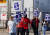 지난 22일(현지시간) 미국 미시간주에서 열린 전미자동차노조(UAW) 파업에 참여한 노동자들이 피켓을 들고 행진하고 있다. [로이터=연합뉴스]