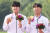 아시안게임 골프 단체전 시상식장에서 금메달을 들어보이는 장유빈(왼쪽)과 조우영. [뉴시스]