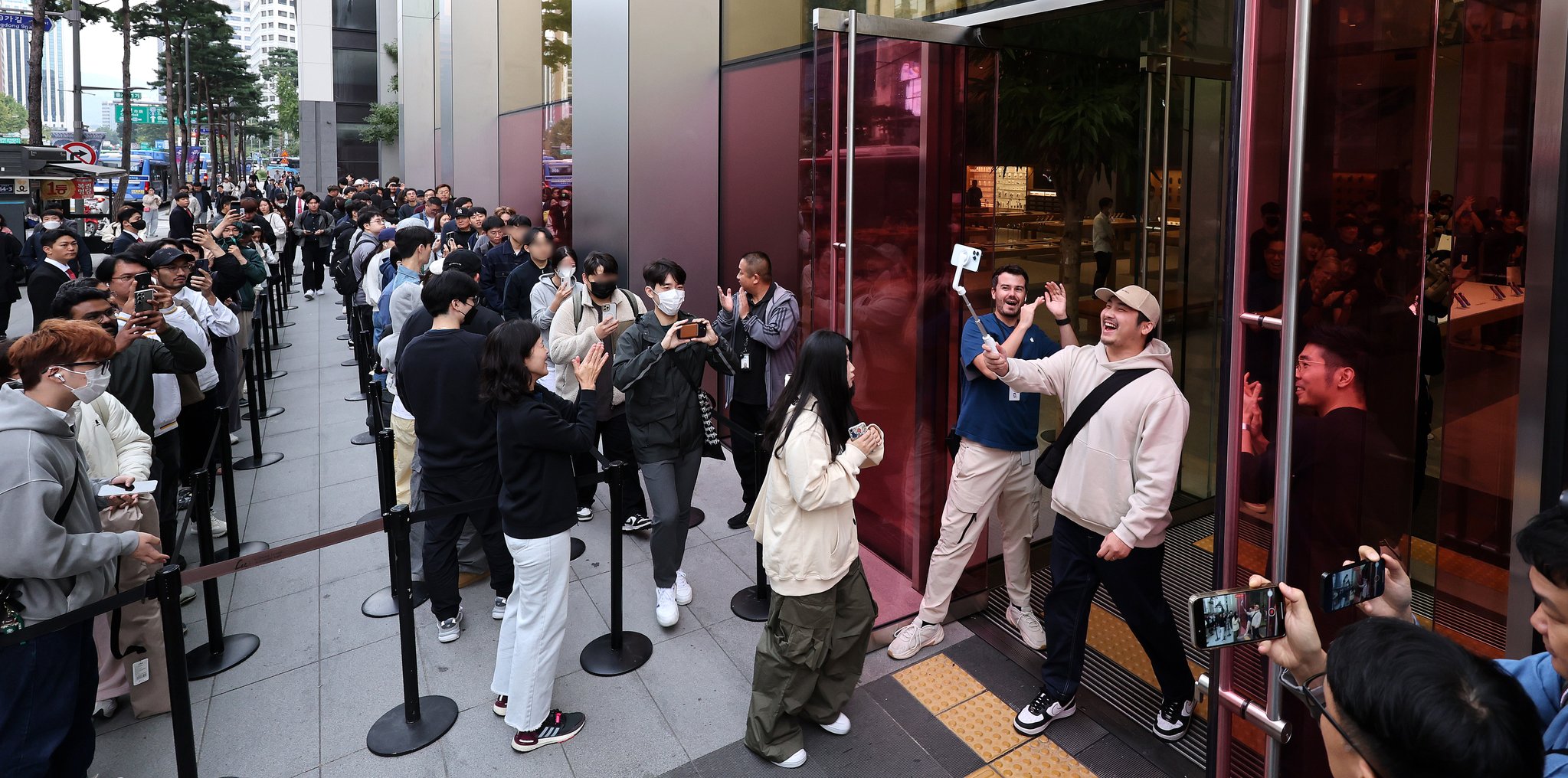아이폰15 시리즈 국내 정식 출시일인 13일 서울 애플스토어 명동점에서 아이폰 예약구매 첫번째 입장 고객이 셀프영상을 찍으면 입장하고 있다. 뉴스1
