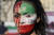  지난해 10월 이탈리아 로마에서 개최된 이란 여성 마흐사 아미니 추모 시위에서 한 여성이 얼굴에 페인팅을 하고 있다. 아미니는 히잡을 제대로 착용하지 않았다는 이유로 이란의 '종교 경찰'에게 붙잡혀 갔다가 사망했다. AP=연합뉴스