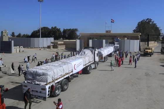 21일(현지시간) 가자 지구를 위한 인도주의적 구호품을 실은 이집트 트럭들이 라파 국경 관문을 건너고 있다. AP=연합뉴스