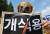 이원복 한국동물보호연합 대표가 지난 8월 31일 서울 여의도 국회 앞에서 열린 개식용 금지법의 국회 연내 통과를 촉구하는 기자회견에서 개식용 반대 퍼포먼스를 하고 있다. 뉴스1