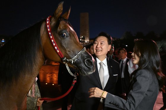 사우디아라비아를 국빈 방문한 윤석열 대통령과 부인 김건희 여사가 지난 21일(현지시간) 리야드 인근 디리야 유적지를 방문해 아라비아 말을 바라보고 있다.<br> 사진 대통령실