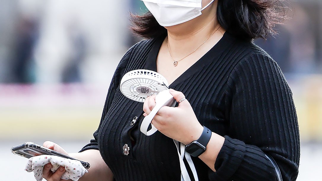 서울 종로구 세종대로 인근에서 2일 한 시민이 손선풍기를 들고 이동하고 있다. 뉴시스