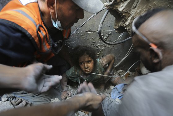 1일(현지시간) 가자지구 북부 자발리야 난민캠프에서 이스라엘 공습으로 파괴된 건물의 잔해에서 팔레스타인인들이 한 소녀를 구출하려고 노력하고 있다. 세이브 더 칠드런(Save The Children)은 지난 10월 가자지구에서 사망한 어린이가 2022년 전 세계 모든 분쟁 지역에서 사망한 어린이를 합친 것보다 더 많다고 밝혔다. AP=연합뉴스